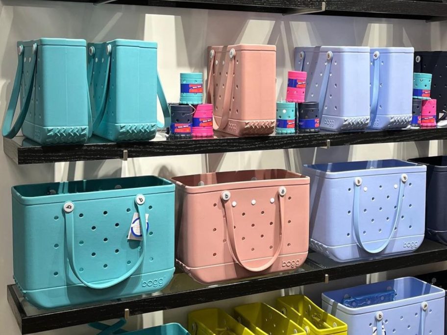 Shelves with colorful Baby Bogg Bag totes and Boozies can holders
