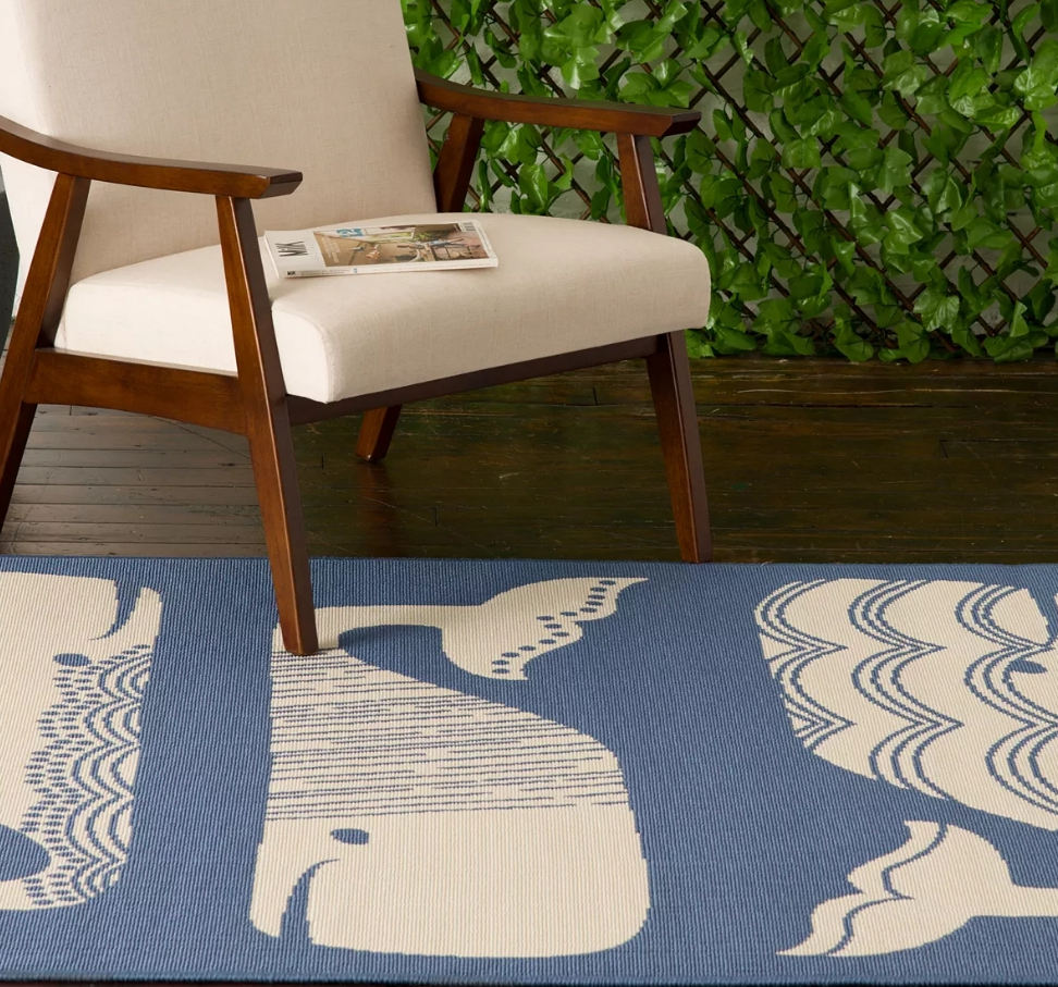 Chair sitting on a blue rug with white whales printed on it