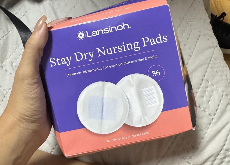 hand holding a box of lansinoh nursing pads