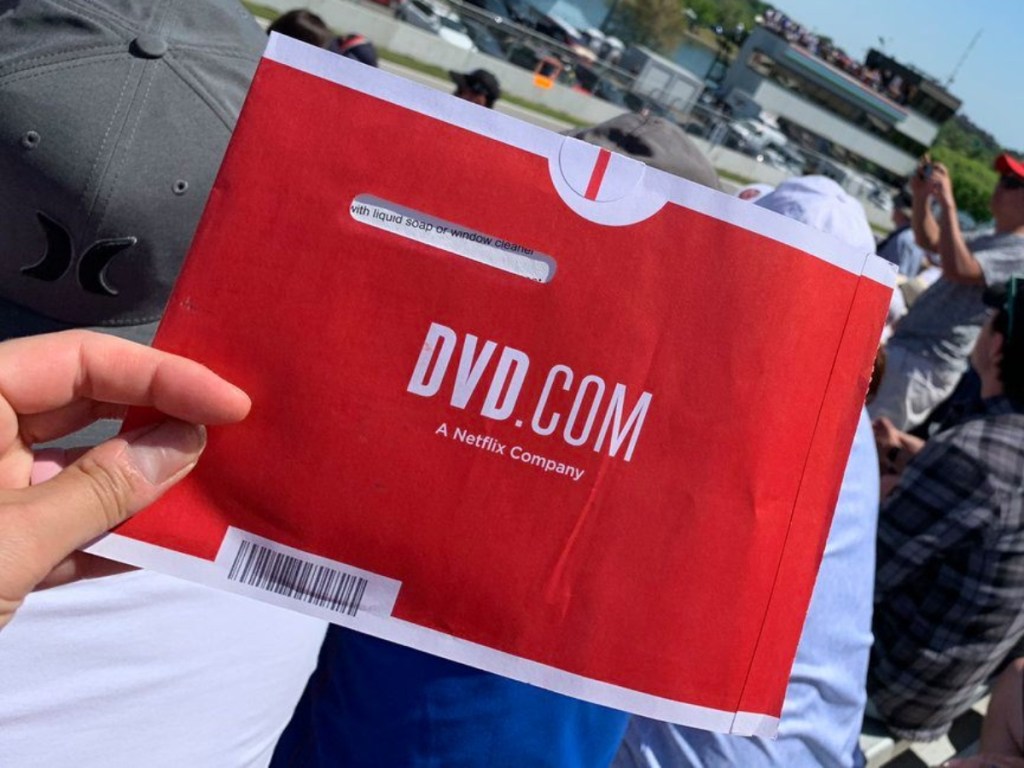 holding a red DVD envelope