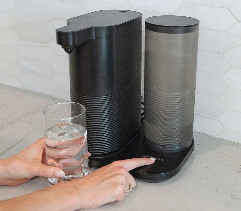Hand pressing a button on a water dispenser