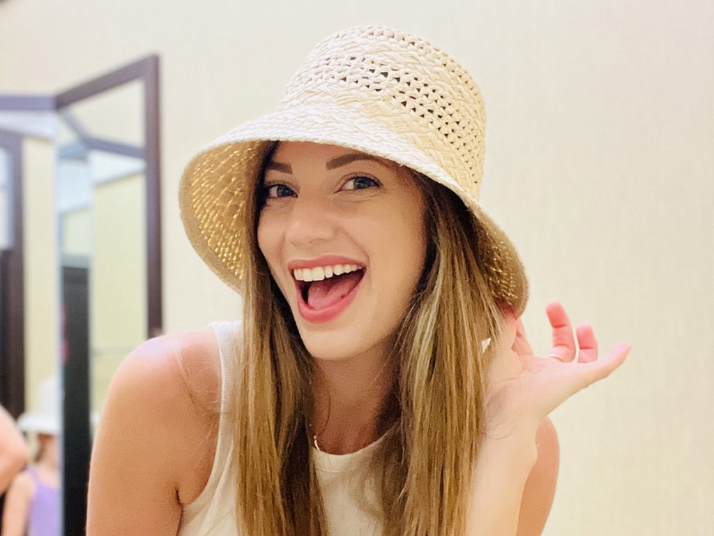 woman trying on a straw hat