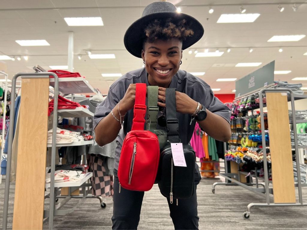 A woman holding 3 wild fable fanny packs