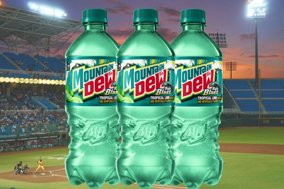three baja blast soda bottles in front of baseball field