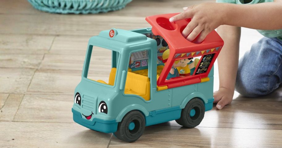 kid playing with Fisher-Price Little People Musical Food Truck