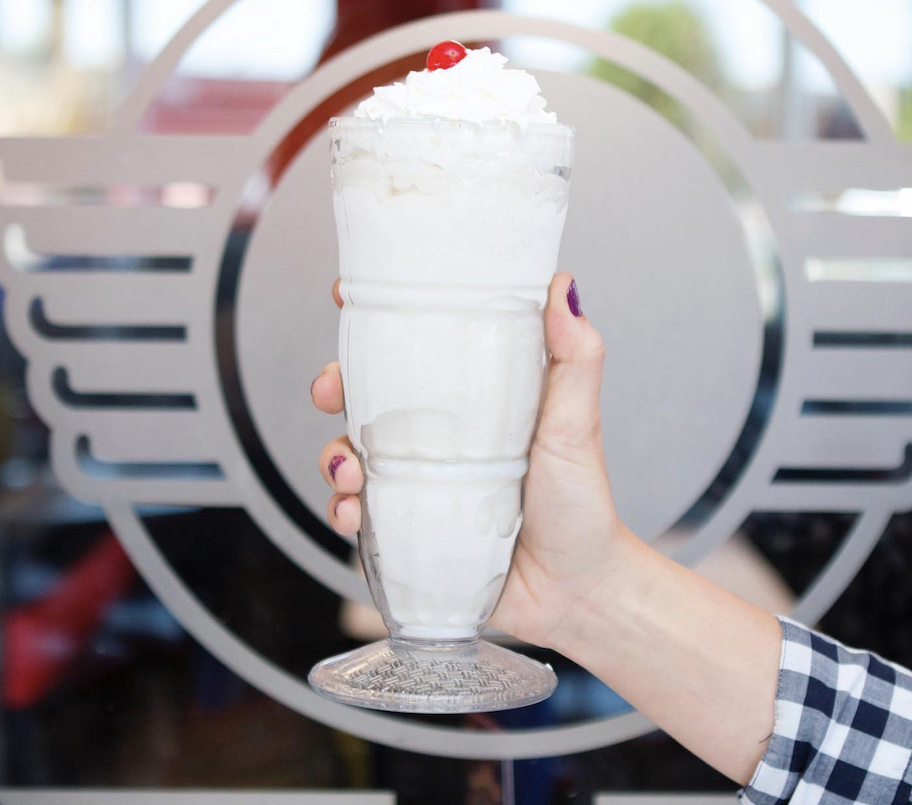 hand holding a vanilla milkshake