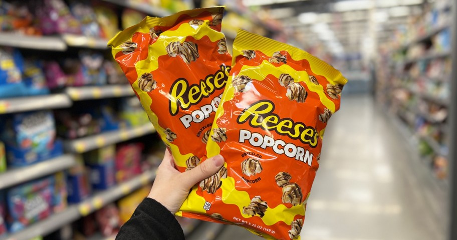 hand holding up two bags of Reese's Popcorn