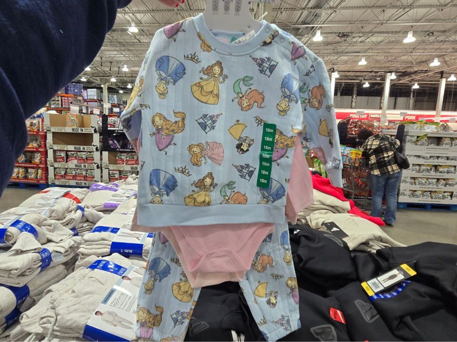 person holding disney princess 4 piece clothing set in store