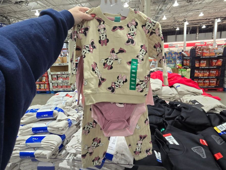 person holding minnie mouse 4 piece clothing set in store