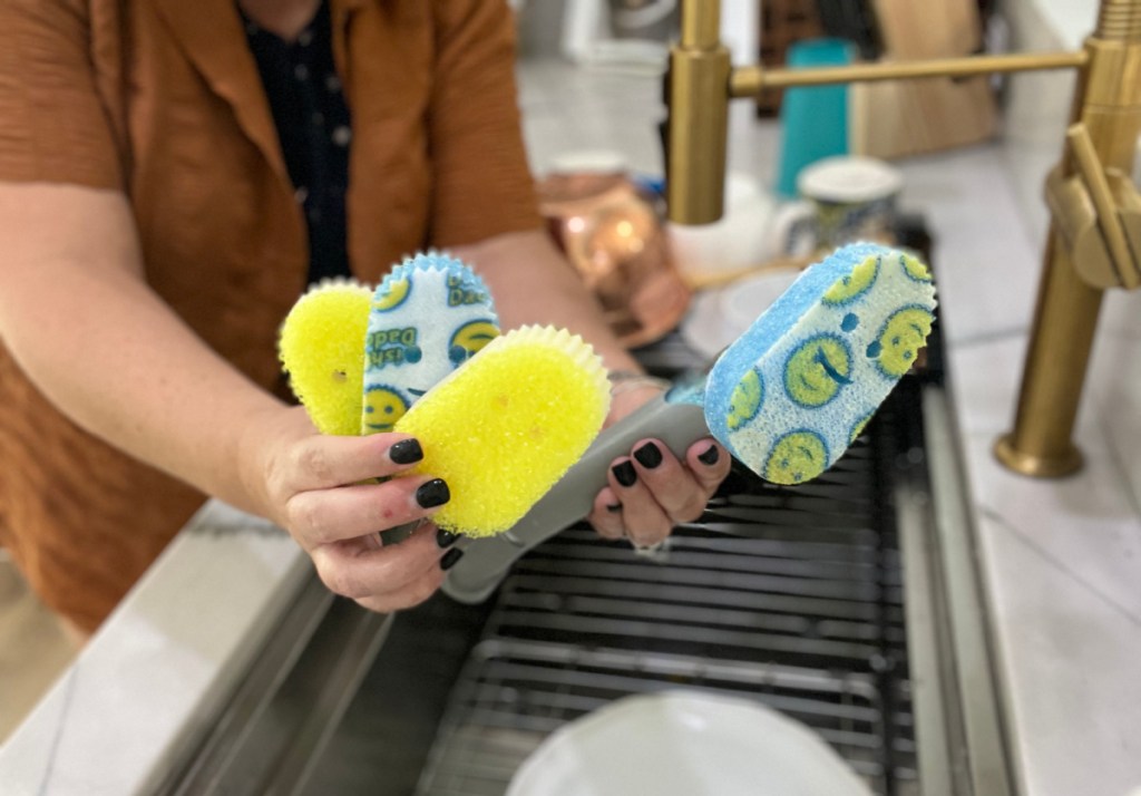 Hand holding a Scrub Daddy Wand with multiple attachments from QVC