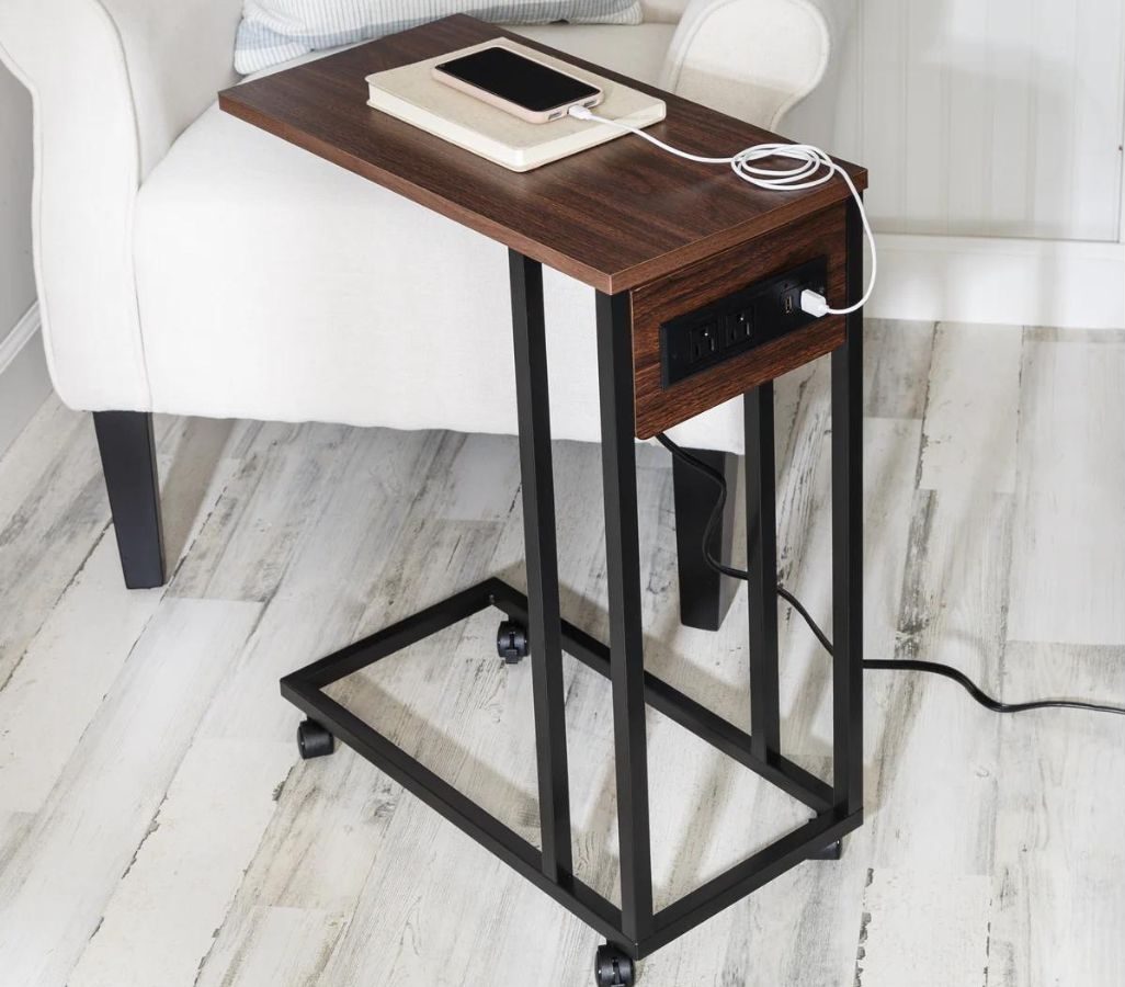 Stock image of a Honey Can Do Side table with built-in outlets set next to a chair