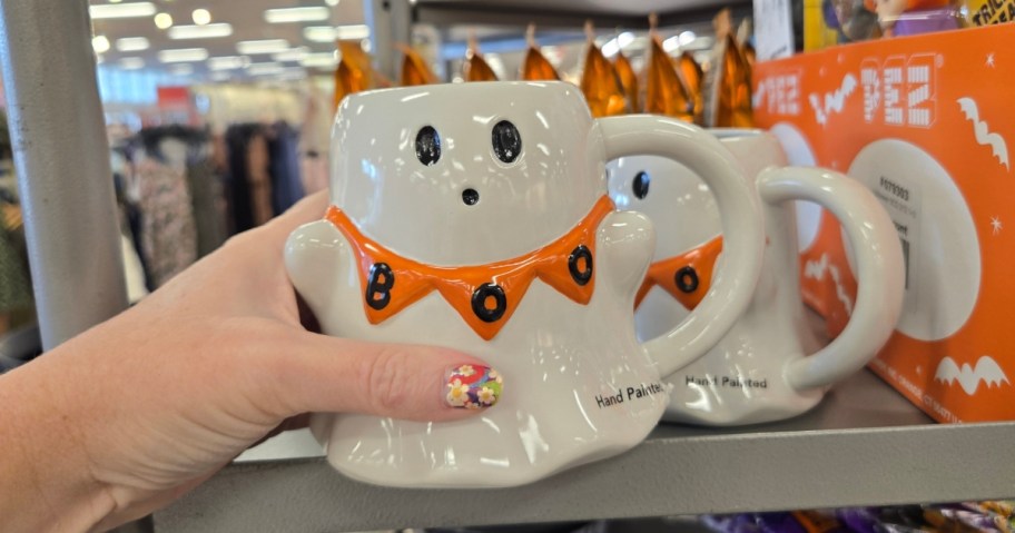 hand holding a ghost coffee mug
