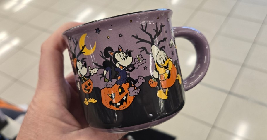 hand holding a Disney Halloween coffee mug