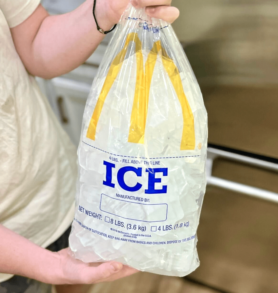boy holding large bag of ice 