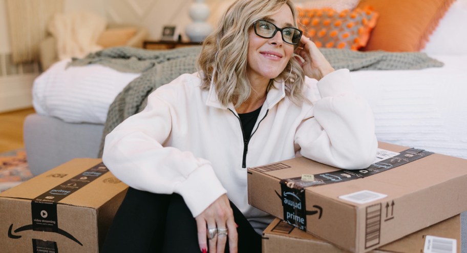 woman surrounded by Amazon boxes in the bedroom