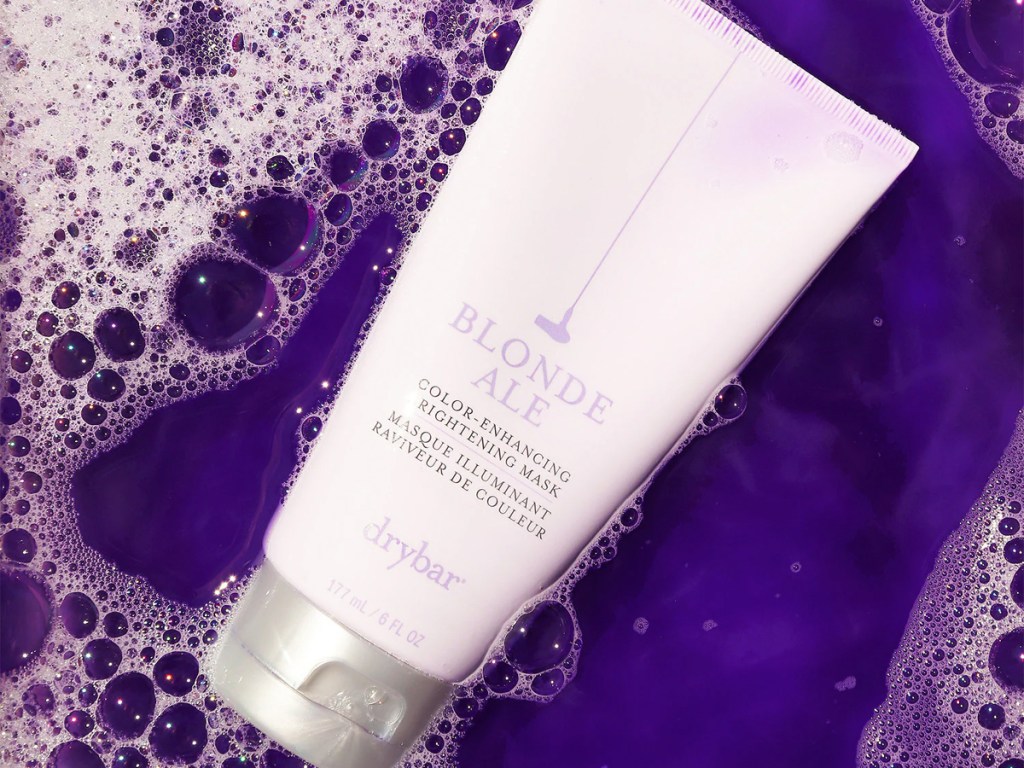 bottle of Drybar Blonde Ale Color-Enhancing Brightening Hair Mask floating in purple water