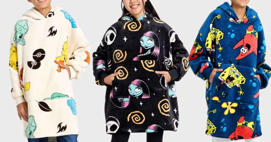 3 kids wearing oversized plush character hoodies
