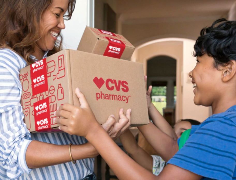 woman handing a boy a CVS box