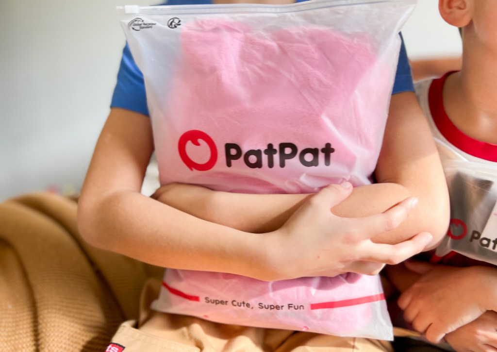kid holding patpat shipping bag