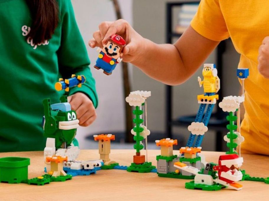2 kids playing with a LEGO Super Mario Big Spike&rsquo;s Cloudtop Challenge Expansion Set