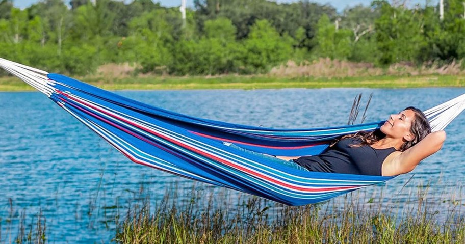 woman laying in hammock near the water 