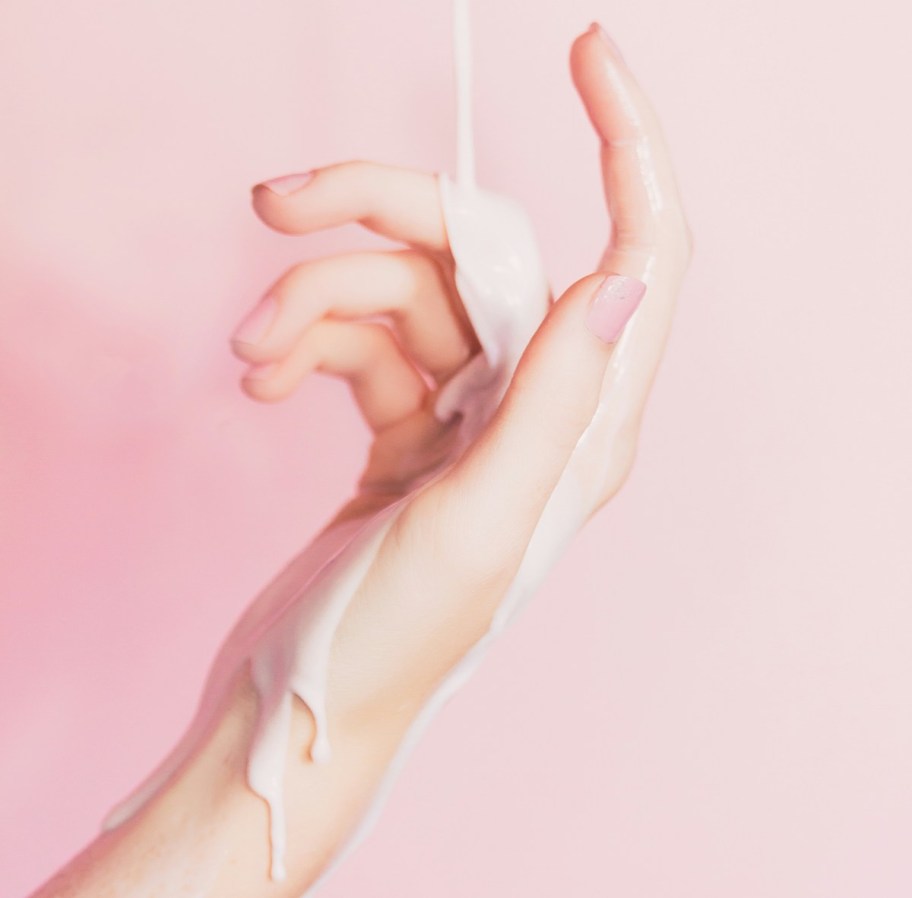 hand with lotion pouring down palm and wrist