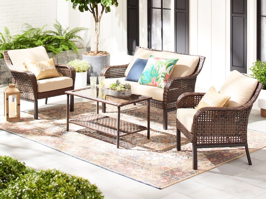 wicker chairs and loveseat with white cushions and matching coffee table