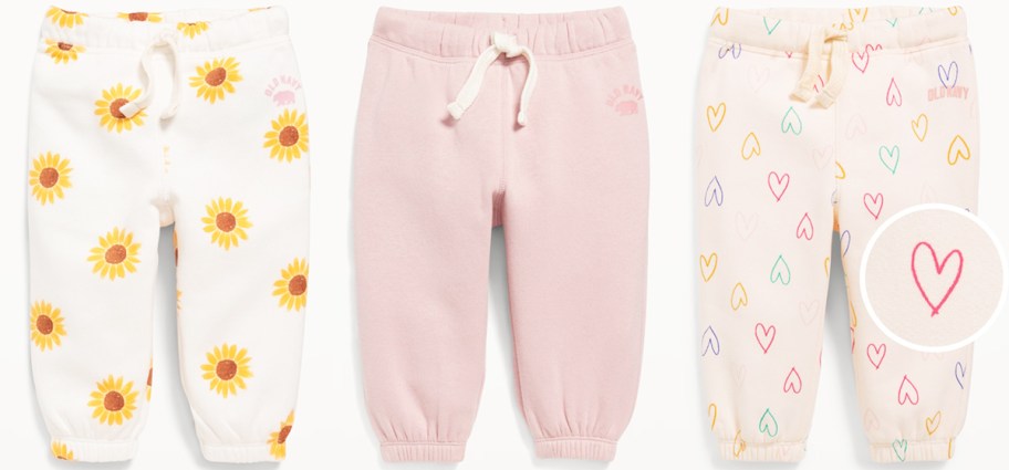 three pairs of joggers in sunflower print, solid pink, and heart print