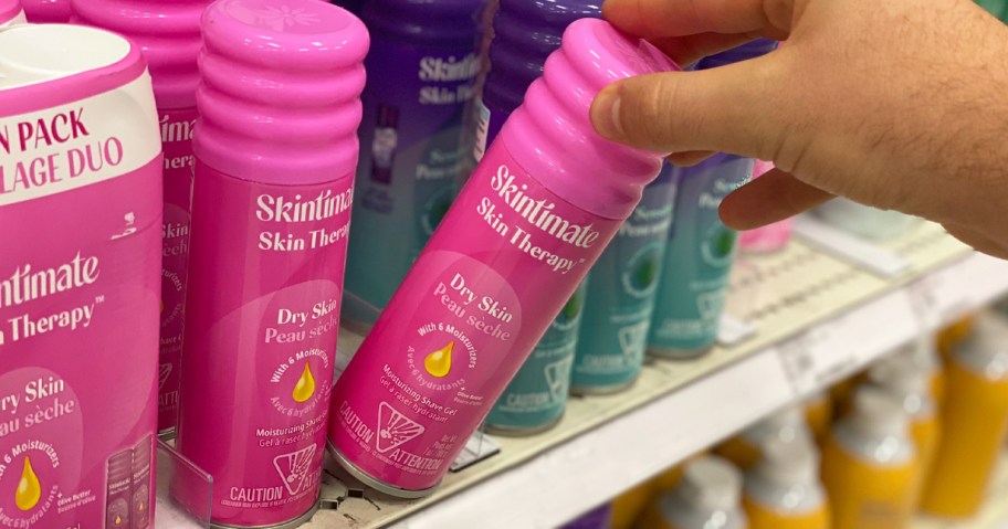 hand grabbing a pink can of Skintimate Shave Gel from store shelf