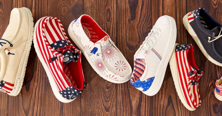 various kids and adults HEYDUDE Americana red, white, blue design shoes on a wood floor