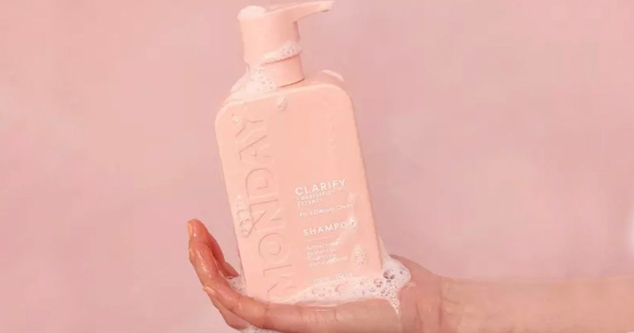 hand holding clarify monday shampoo bottle 