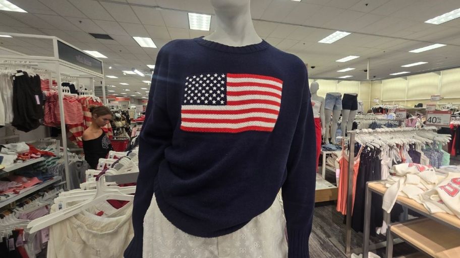 a store manequin wearing a navy blue sweater with an american flag graphic