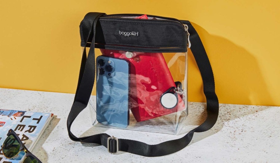 baggallini clear crossbody bag with black details and items in purse