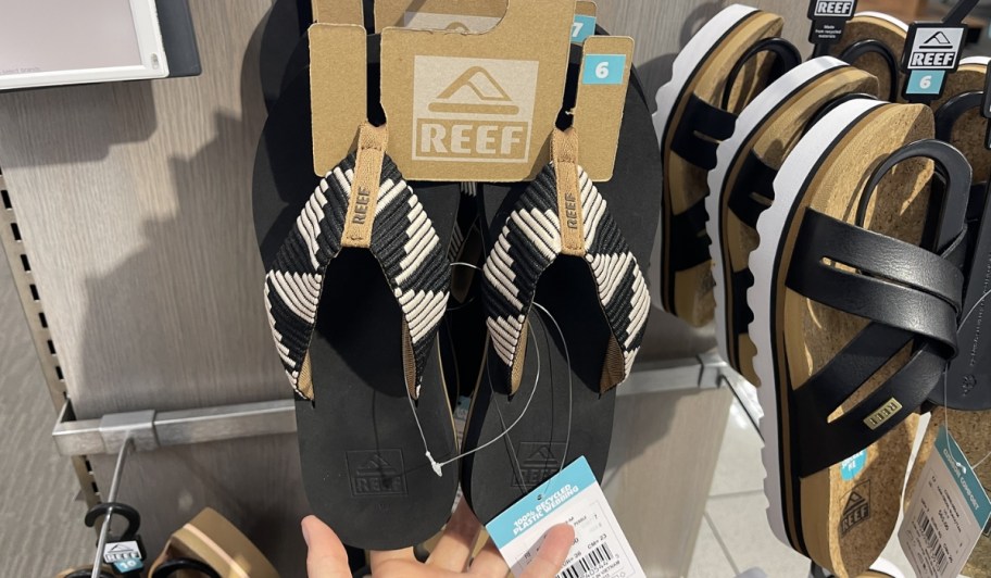 reef flip flops in black hanging in store