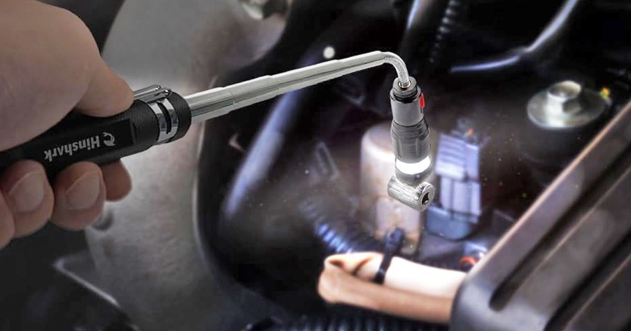 hand using a magnetic pickup tool to get loose bolt from car