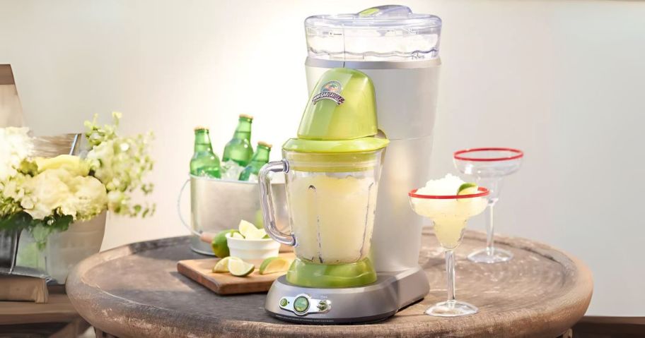 Margaritaville Bahamas Frozen Concoction Maker w/ No-Brainer Mixer on table with drinks and limes next to it