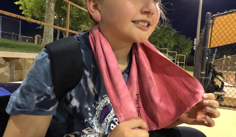 girl with red cooling towel on neck at softball game