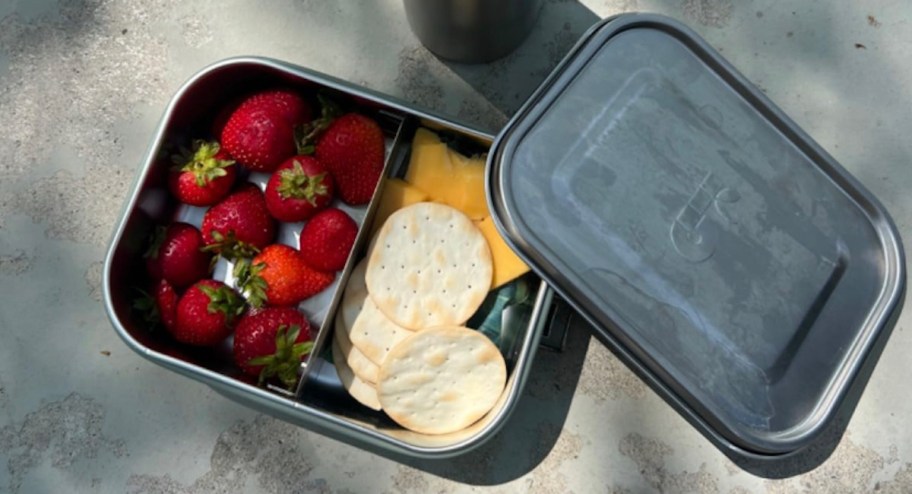 stainless steel lunch box with strawberries and crackers