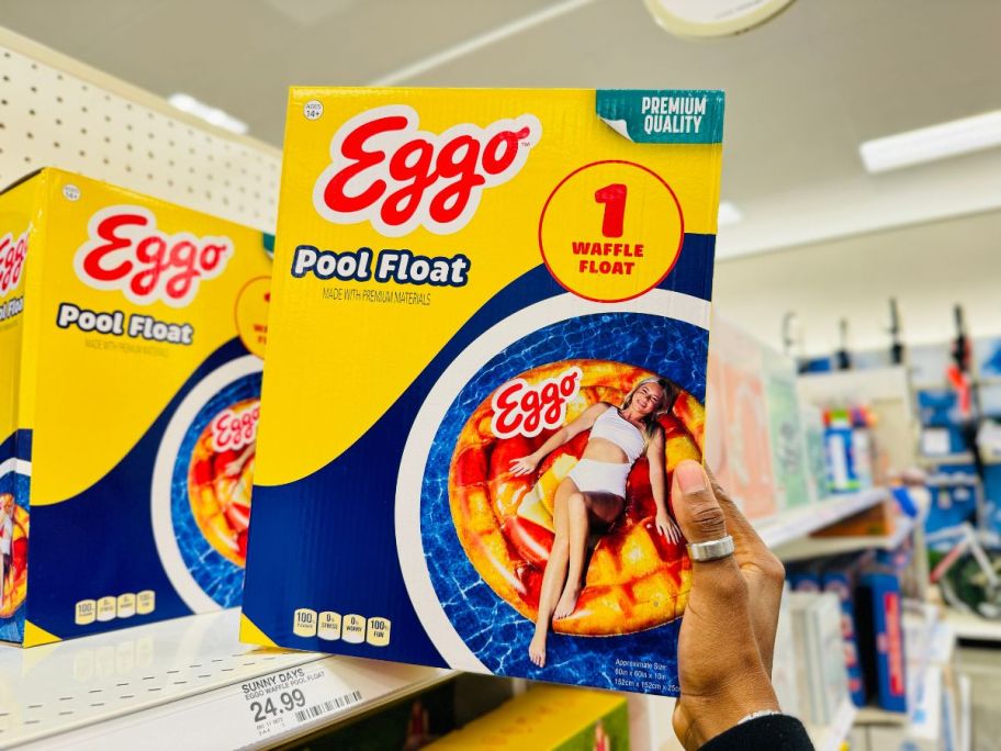 A person holding an Eggo Waffle Pool Float box in a store
