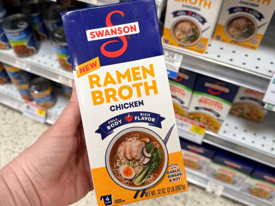 person holding up box of Swanson Ramen Chicken Broth