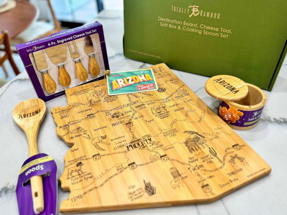 A Totally Bamboo Destinations Cutting Board Set shaped like Arizona with a spoon, cheese knife set and salt cellar