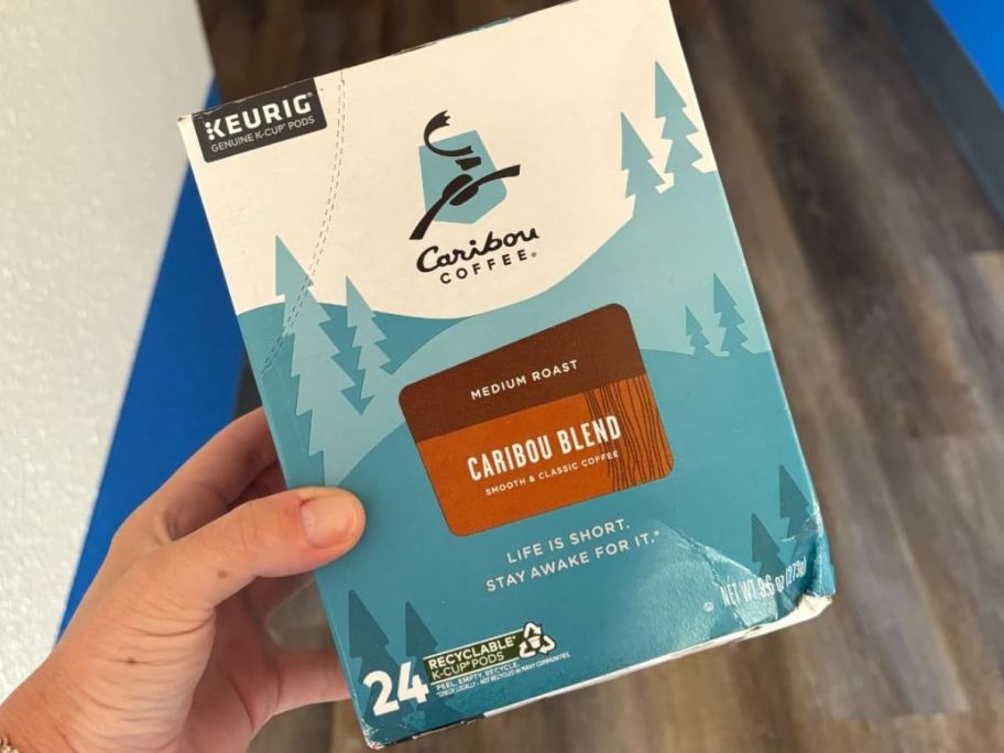 hand holding caribou coffee kcup box
