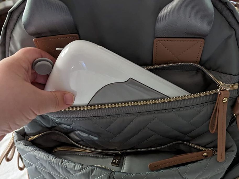 person pulling OXO Tot On-The-Go Wipes Dispenser out of diaper bag