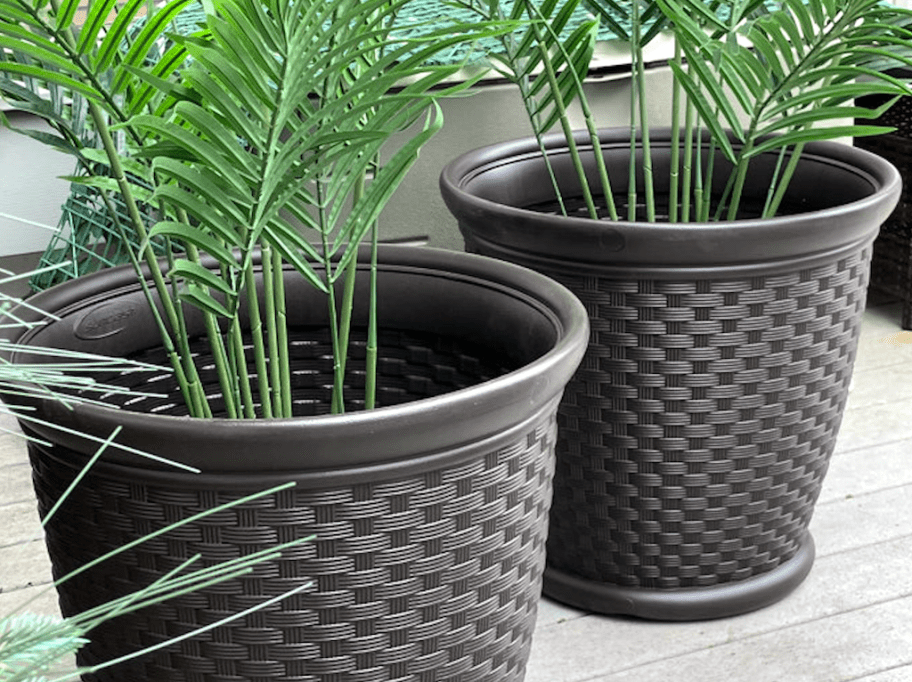 faux plants inside two brown planters 