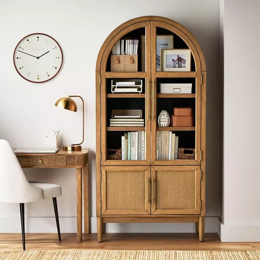 a large natural wood arched cabinet in a living room