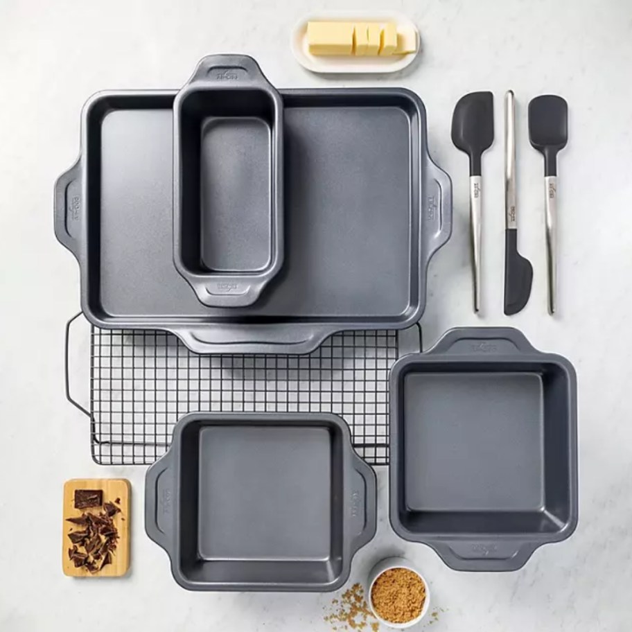 a set of bakeware and kitchen utensils on a table
