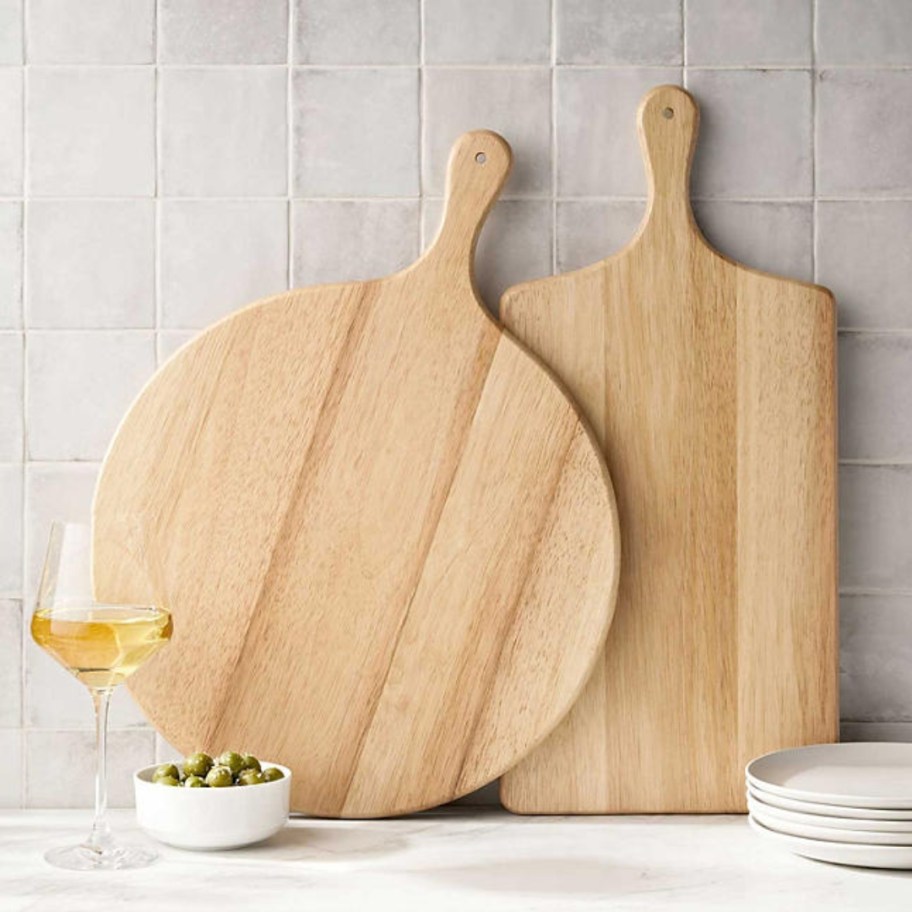 a round and a rectangle wood charcuterie board on a kitchen counter
