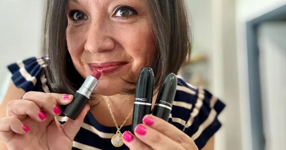 woman holding three mac lipsticks