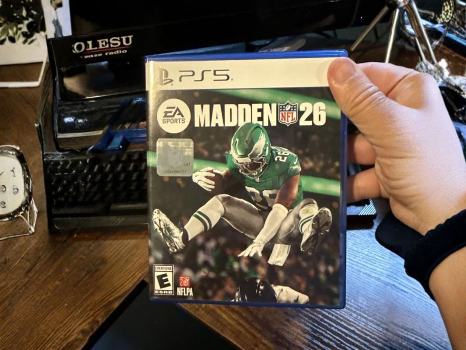hand holding madden 26 ps5 video game
