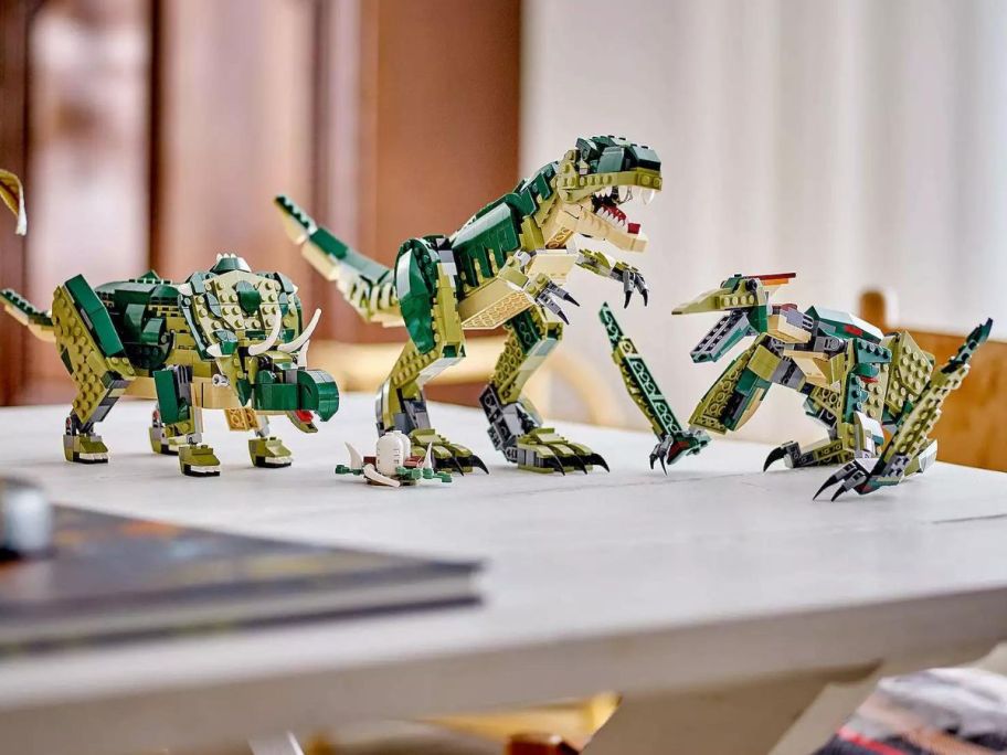3 lego dinosauce sets on table